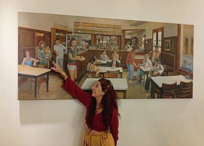 Victoria Oyhanarte, actual dueña del bodegón, señala un cuadro de Daniel Kaplan que retrata a sus trabajadores