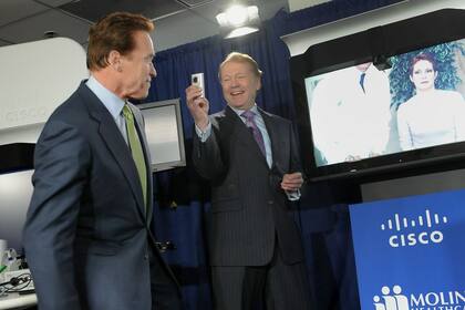 Viejos tiempos. El CEO de Cisco John Chambers filma con una cámara Flip al gobernador Arnold Schwarzenegger durante una conferencia de prensa