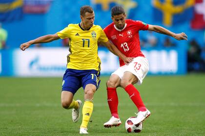 Viktor Claesson de Suecia pelea por la pelota con Ricardo Rodriguez de Suiza