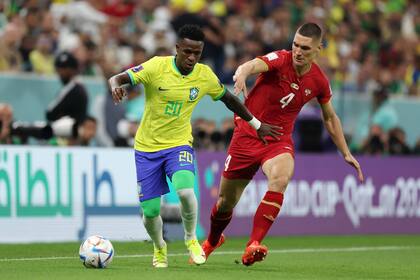 Vinicius Jr., de Brasil con Nikola Milenkovic, de Serbia, durante el partido de la fecha 1