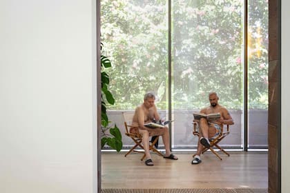 Visitantes en traje de baño se sientan a leer libros durante la experiencia denominada "Día de los bañistas"