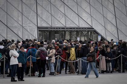 Visitantes formando fila en la entrada principal para ingresar al Museo del Louvre