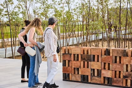 Visitantes frente a la obra de Florencia Sadir en la exposición de Mueble Escultura en el bosque de alisos