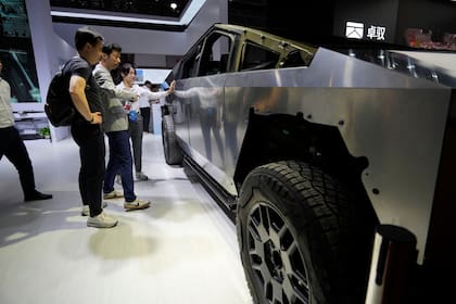 Visitantes miran una versión básica del Cybertruck de Tesla con dispositivos de AOD Technology, que fabrica unidades de control de dominio que procesan diversos comandos como abrir puertas y controlar estribos en SUV, exhibida en la feria automotriz de Shanghái el jueves 24 de abril de 2025. (AP Foto/Ng Han Guan)