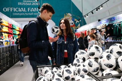 Visitantes recien llegados en la tienda oficial del FIFA Fan Fest en Moscú, con la pelota mundialista