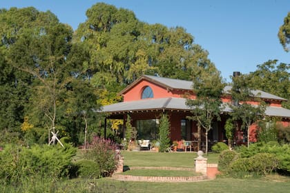 Vista de la casa principal rodeada de jóvenes Gleditsia triacanthos f. inermis ‘Sunburst’. Un cambio de nivel fue definido con una escalera circular de ladrillo