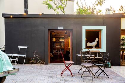 Vista de la entrada de la biblioteca desde el patio. En el medio hay una “callecita estilo europeo” con mesas y sillas de hierro.