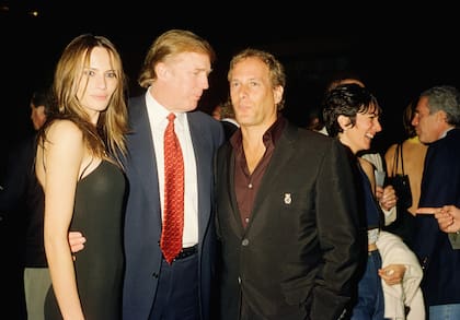 Vista de la exmodelo Melania Knauss (posteriormente Trump) y Donald Trump (centro) posando con el músico Michael Bolton en el club Mar-a-Lago, Palm Beach, Florida, el 12 de febrero de 2000. Al fondo, se ven la socialité británica Ghislaine Maxwell (segunda a la derecha) y el financiero estadounidense Jeffrey Epstein