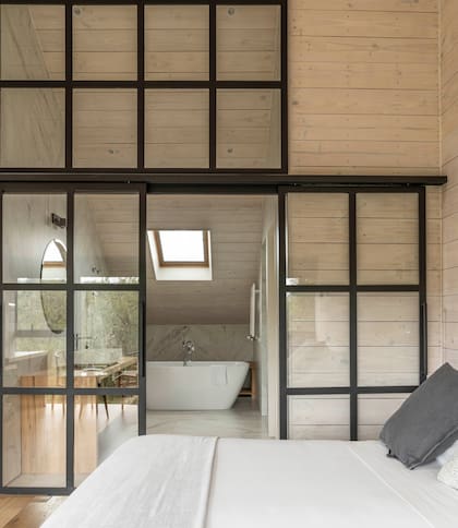 Vista de la suite con puerta de vidrio repartido al baño.