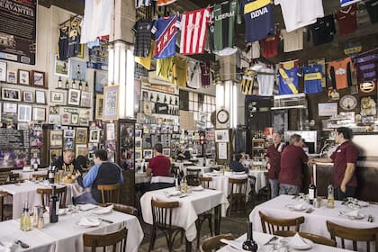 Vista del salón de El Obrero, con las camisetas colgadas en el techo y las paredes llenas de retratos