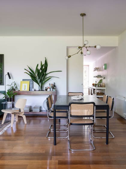 Vista desde le comedor hacia la cocina, separados por otra enorme puerta corrediza. Sobre la barra de madera, obra amarilla (Monocopia).