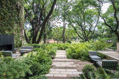 Vista general de la amplia terraza plantada con
poca variedad de especies. Se destaca el camino de travertino y rajas de piedrita y se ven los diferentes espacios de uso.