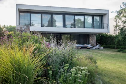 Vista trasera de la casa, donde se empleadron gramíneas que aportan color y enmarcan los canteros.