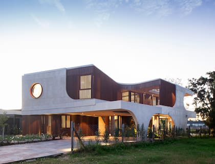 Vista trasera de Laguna House, donde las curvas del diseño se combinan con el paisaje