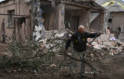 Petr Lisovoi, de 61 años, trabaja para retirar los escombros de una casa dañada después de un bombardeo ruso durante la noche, en Sloviansk, región de Donetsk, Ucrania, el lunes 10 de octubre de 2022