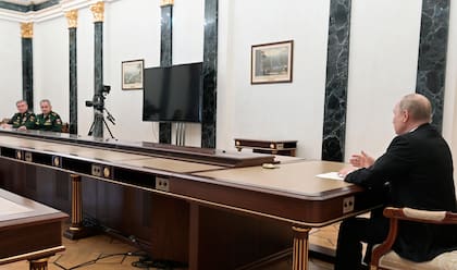 Vladimir Putin, habla con el ministro de Defensa ruso, Sergei Shoigu, y con el jefe del Estado Mayor General de las Fuerzas Armadas de Rusia y primer viceministro de Defensa, Valery Gerasimov, a la izquierda, durante su reunión en Moscú