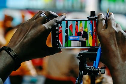 Vladimir Putin se ve en la pantalla de un celular mientras ofrece una declaración en la segunda cumbre Rusia-África