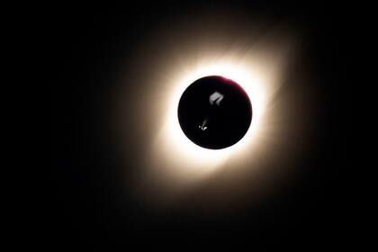 Las luces del parapente iluminaron la vela con el fondo del eclipse total de sol