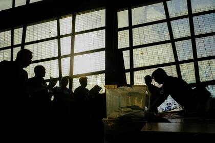 Voluntarios electorales cuentan votos en la antigua estación de tren de Mapocho, durante las elecciones regionales, el domingo 27 de octubre de 2024, en Santiago, Chile. (AP Foto/Esteban Félix)