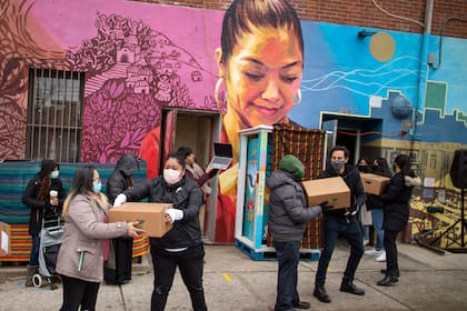 Voluntarios movilizan despensas de alimentos que serán donadas mientras vecinos del barrio reciben información sobre las vacunas contra el Covid en el centro comunitario Mixteca, Brooklyn