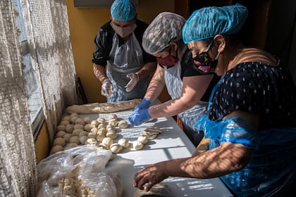 Voluntarios preparan el almuerzo en un comedor popular en el barrio de La Pintana, Santiago, el 25 de mayo de 2020, en medio de la pandemia de coronavirus