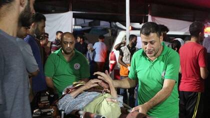 "Voy a Gaza para mostrar solidaridad como médico con mis colegas palestinos", señaló Gilbert; en la imagen paramédicos llevan una mujer mayor herida al hospital Al Shifa