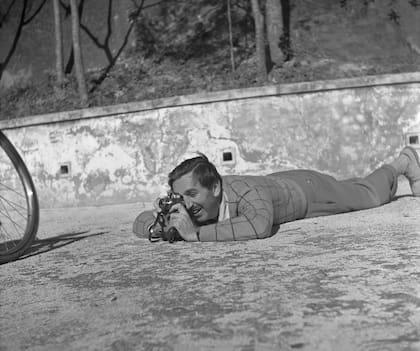 Walt recostado en el piso sacando fotos.