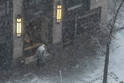 Una Persona cubierta de nieve camina por las calles de Washington