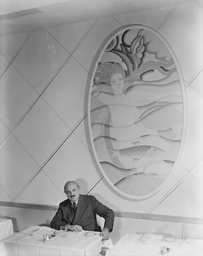 Winold Reiss con uno de sus murales en el restaurante Longchamps del Empire State Building, hacia 1940.