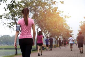 Woman walking in the park with bottle water in summer health care concept.