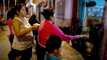 Mujeres hacen fila frente al comedor de Norma Colque
