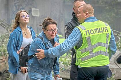 Women react outside a destroyed apartment building after a Russian missile attack in Kyiv, Ukraine, Thursday, July 31, 2025. (AP Photo/Efrem Lukatsky)
