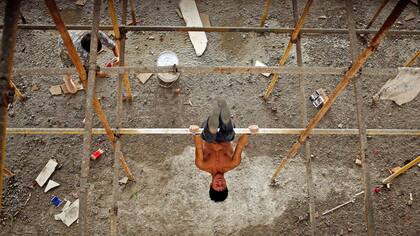Shi Shenwei, realiza una rutina de barra fija, en un andamio de la obra en construcción de un templo budista,en el pueblo de Huangshan, cerca de Quanzhou, provincia de Fujian, China