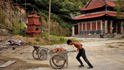 Shi Shenwei, empuja una carretilla donde se construye un templo budista en el pueblo de Huangshan, cerca de Quanzhou, provincia de Fujian, China,