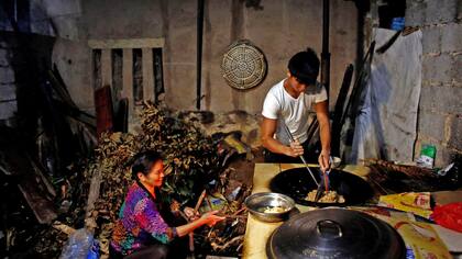 Shi Shenwei y su abuela, preparan el desayuno en la cocina en una casa antigua, que sirve como dormitorio para los trabajadores de una construcción cercana a un templo budista en el pueblo de Huangshan, cerca de Quanzhou,China