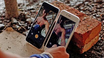 Shi Shenwei, usa sus teléfonos para grabar su rutina de barra fija, en donde se construye un templo budista en el pueblo de Huangshan, cerca de Quanzhou, provincia de Fujian, China