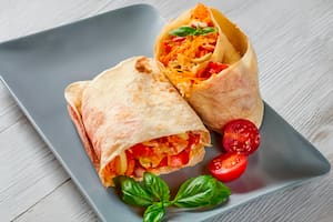 Wrap con hummus, espinaca, tomate cherry y zanahoria rallada