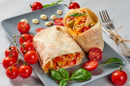 Wrap integral con hummus, espinaca, tomate cherry, zanahoria rallada y semillas de sésamo