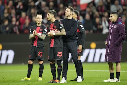 Xabi Alonso, entrenador de Bayer Leverkusen, abraza al argentino Exequiel Palacios, que estuvo entre los suplentes, pero ingresó y fue clave en la clasificación
