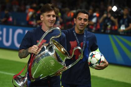 Xavi y Messi, con el trofeo de la Champions League ganado por Barcelona en 2015; ambos podrían volver a juntarse en Cataluña a partir de julio