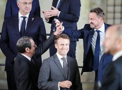Xavier Bettel, primer ministro de Luxemburgo, se da la mano con Nicos Anastasiades, presidente de Chipre, detrás del presidente de Francia, Emmanuel Macron, mientras se reúnen con otros líderes para una foto de grupo en el Castillo de Praga, durante la cumbre de la Comunidad Política Europea. (Kay Nietfeld/dpa)