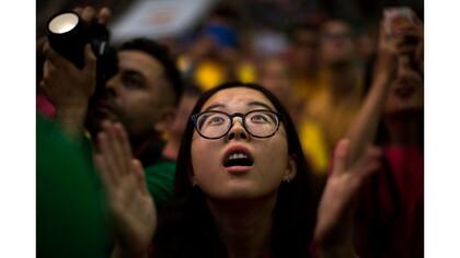 Xiaodong Feng, de 24 años, de China, reacciona mientras mira a los miembros de "Xiquets de Hangzhou" tratando de completar su torre humana, durante la 26 Competencia de la Torre Humana 26 en Tarragona, España