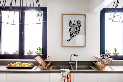 Xilografía de Luisa Freixas. A la mesada de Neolith ‘Cement’ se le dio más grosor para destacar su aspecto de piedra sólida. Muebles laqueados (Estudio Tomás Magrane) con cajones de diferentes profundidades y guías ‘Tandem’ (Blum) con freno.