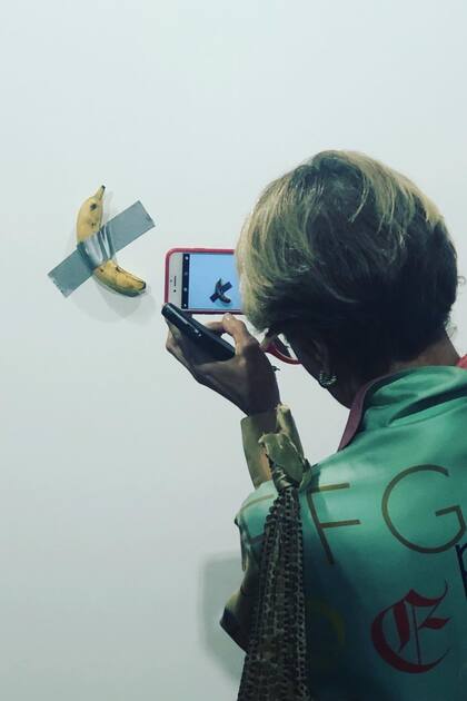 El público desfiló en Art Basel Miami para registrar la obra de Cattelan