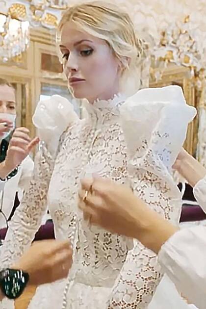 Ya maquillada, Kitty deja que le acomoden el traje antes de caminar hacia el altar.