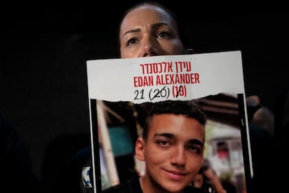 Yael Alexander muestra un cartel de su hijo, Edan, tomado como rehén por milicianos de Hamás el 7 de octubre de 2023, en una marcha semanal de familiares de rehenes retenidos en la Franja de Gaza y sus simpatizantes, en Tel Aviv, Israel, el sábado 22 de febrero de 2025. (AP Foto/Maya Alleruzzo)