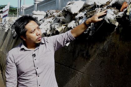 Heri Andreas señala un dique construido para evitar que el agua del mar inunde las casas cuando llueve
