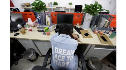 Yang Juan, un empleado de Gopal Grupo, toma una siesta en su asiento después del almuerzo