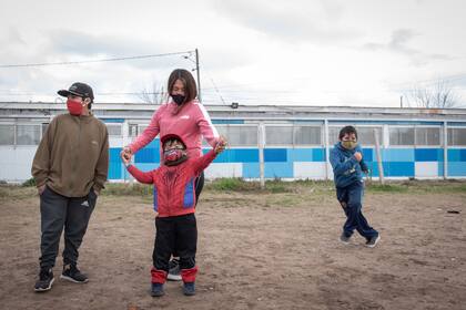 Yanina junto a tres de sus cinco hijo; ellos iban a un espacio de acompañamiento escolar que terminó brindando ayuda alimentaria por la necesidad de las familias 