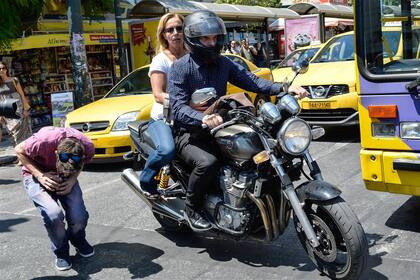 Yanis Varoufakis y su mujer se retiran en moto del ministerio de Finanzas griego en 2015.